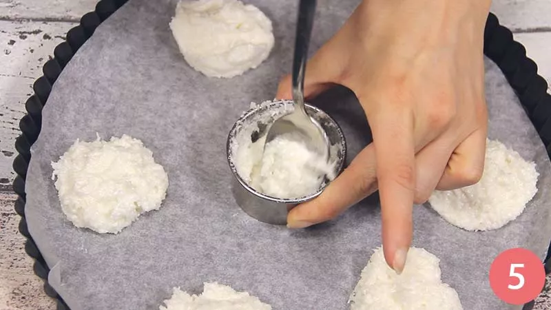 Prendiamo una teglia rivestita di carta da forno e formiamo dei piccoli dischi con il composto