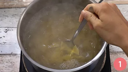 Mentre le farfalle cuociono in acqua bollente salata
