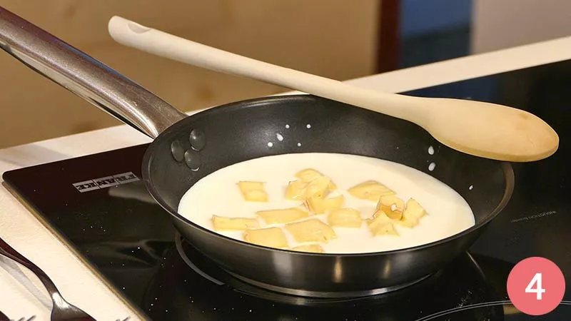Aggiungiamo i dadini di formaggio al latte sul fuoco e li facciamo sciogliere fino ad ottenere una crema omogenea